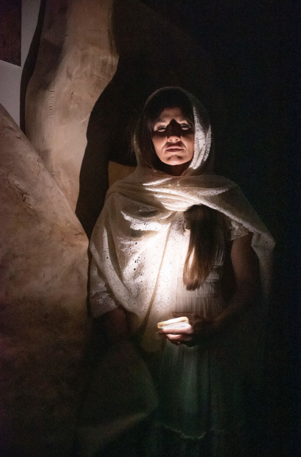 Volunteer in white robe near tomb